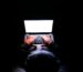A person in a dark room typing on a laptop, symbolizing privacy, cybersecurity, and technology.